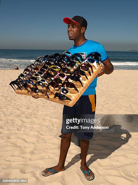 sunglass vendor on beach - straßenverkäufer stock-fotos und bilder