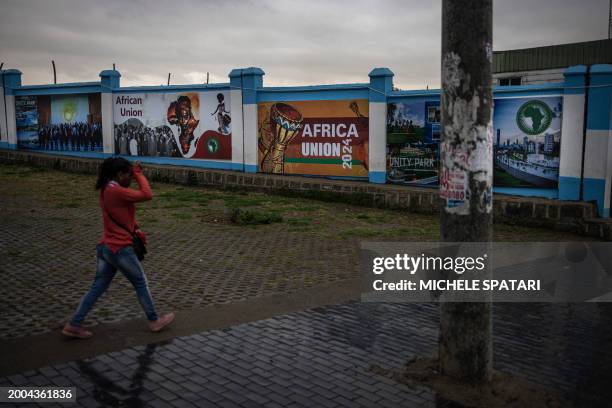 Woman walks by banners dedicated to the African Union in the historical Piazza neighbourhood of Addis Ababa on February 15 as the city prepares to...