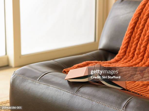 open book on leather chair - armchair stock pictures, royalty-free photos & images