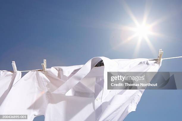 button down shirts hanging from clothesline outdoors - lessive photos et images de collection