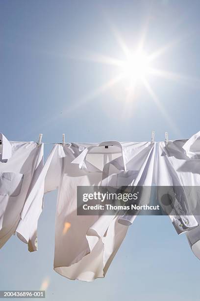 button down shirts hanging from clothesline outdoors, low angle view - white button down shirt stock pictures, royalty-free photos & images