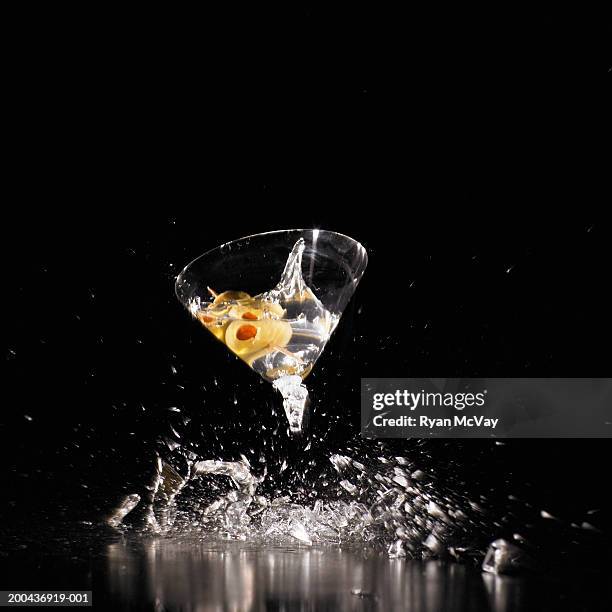 martini glass shattering on floor (blurred motion) - martini glass stock-fotos und bilder