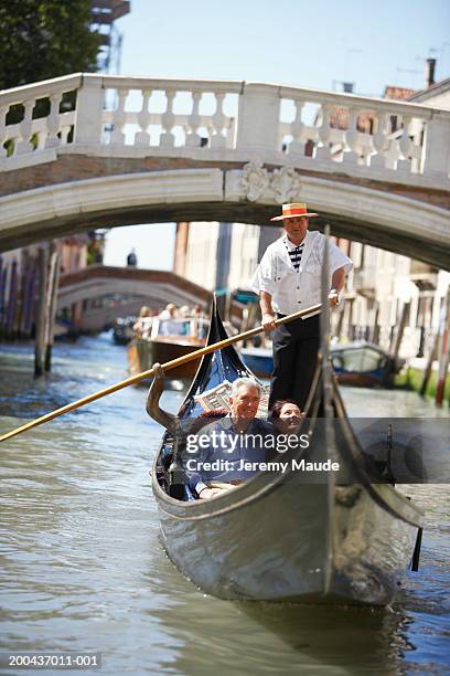 italy, venice, mature couple in gondola on canal, smiling - venedig gondel stock-fotos und bilder