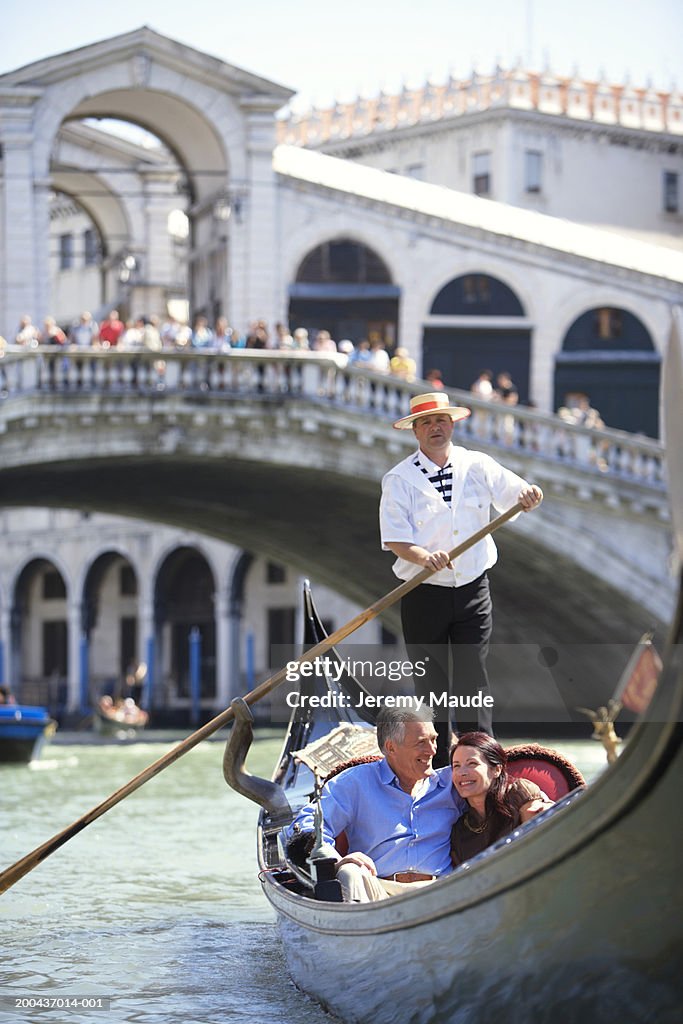 Italy, Venice, mature couple in gondola on canal, smiling