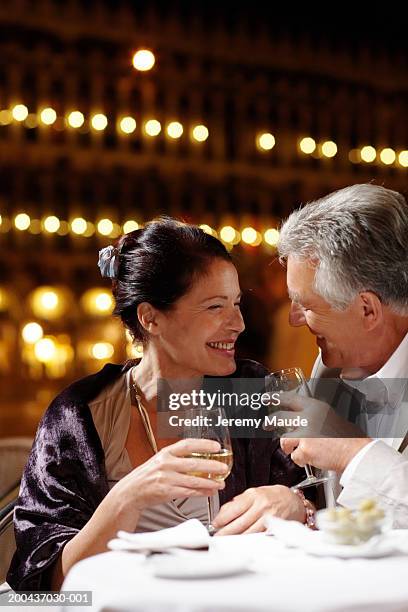 couple having drinks at restaurant in square, smiling, night - evening wear bildbanksfoton och bilder