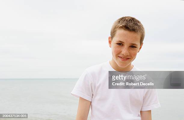 boy (11-13) standing on beach, smiling, portrait - junge 13 jahre oberkörper strand stock-fotos und bilder