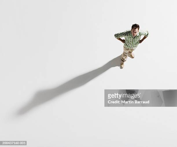 young man standing with hands on hips, portrait, overhead view - overhead view foto e immagini stock