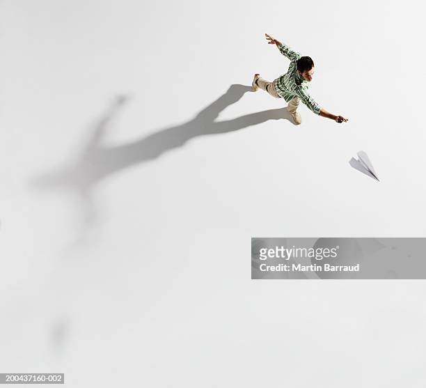 young man throwing paper aeroplane, overhead view - throwing fotografías e imágenes de stock