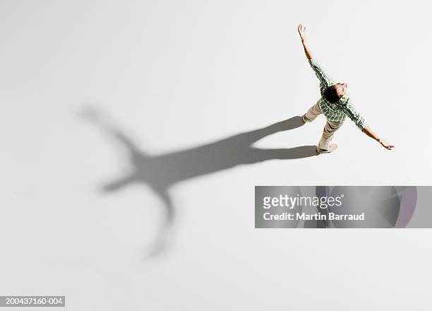 young man standing with arms outstretched, overhead view - freedom stock pictures, royalty-free photos & images