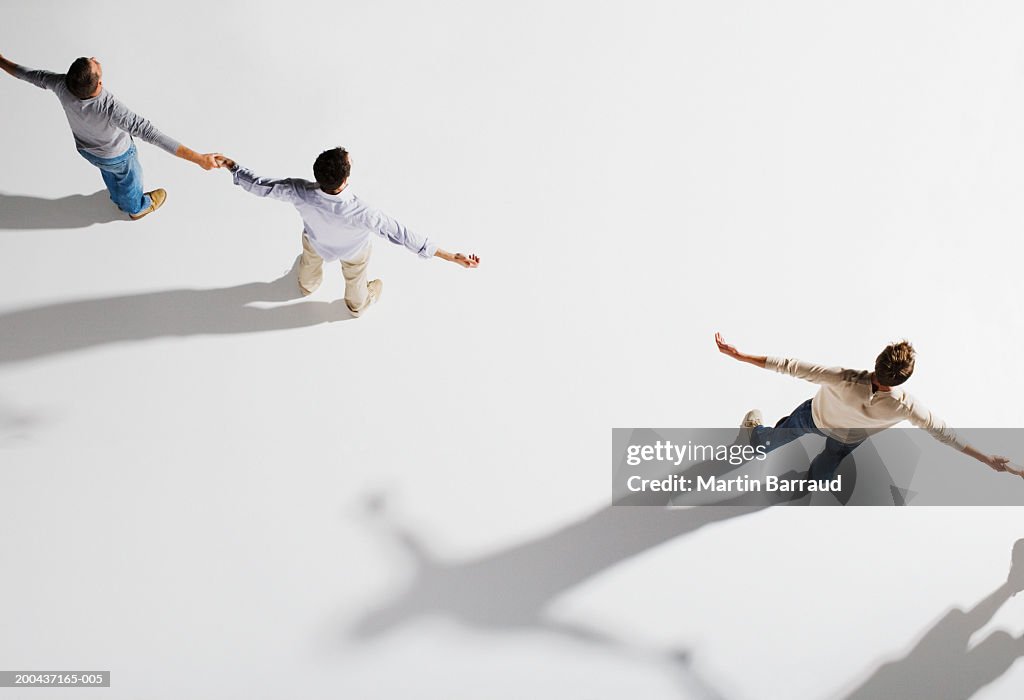 Two pairs of people holding hands, gap between pairs, overhead view