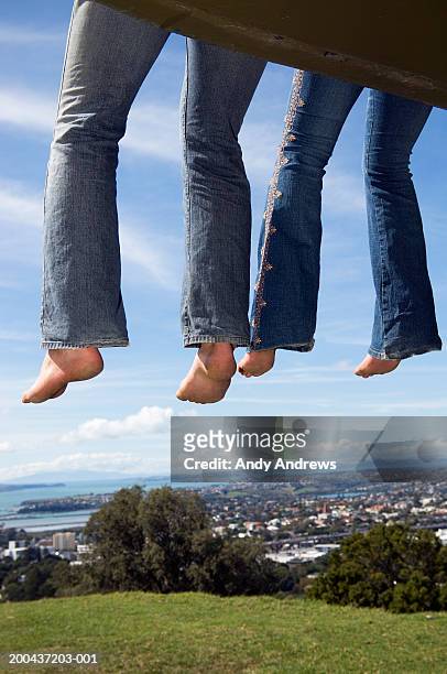 couple sitting on platform over field, low section - girlfriend feet stock pictures, royalty-free photos & images