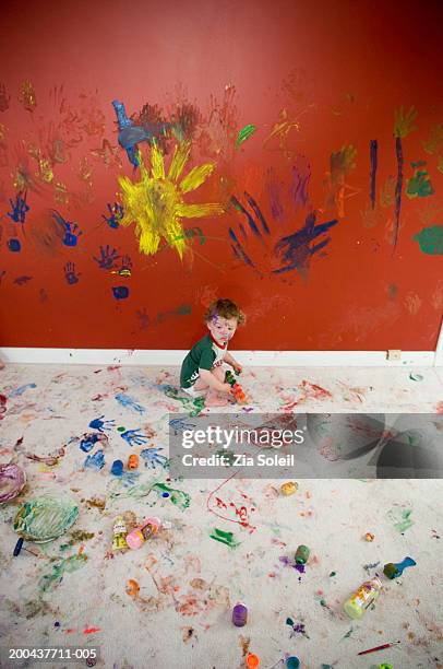 male toddler (12-15 months playing with paints, side view - farbe wand stock-fotos und bilder