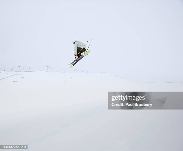 young male skier mid-air, rear view - banff stock-fotos und bilder