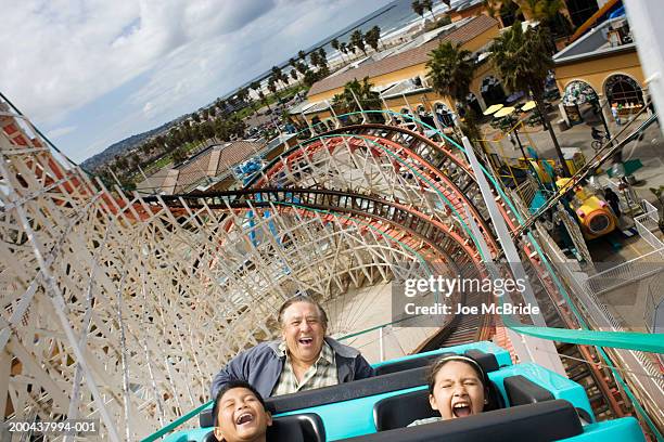 grandfather and grandchildren (9-11) riding rollercoaster - mission bay san diego stock pictures, royalty-free photos & images