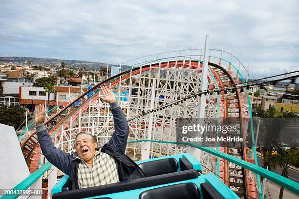 senior man with hands raised, riding rollercoaster - mission bay san diego stock pictures, royalty-free photos & images