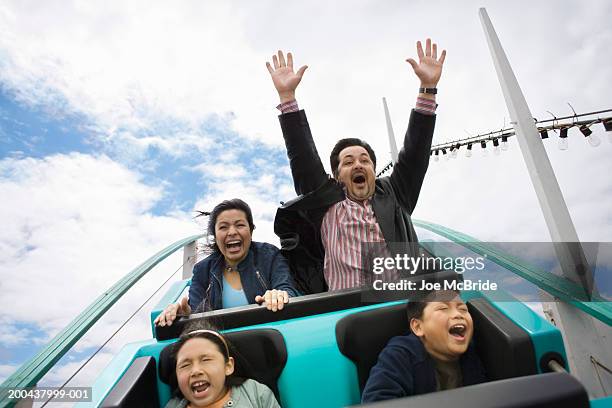 family riding rollercoaster, father with hands up in air - euforie stockfoto's en -beelden