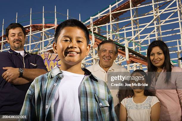 three generation family at amusement park, boy (10-12) in foreground - famille montagnes russes photos et images de collection