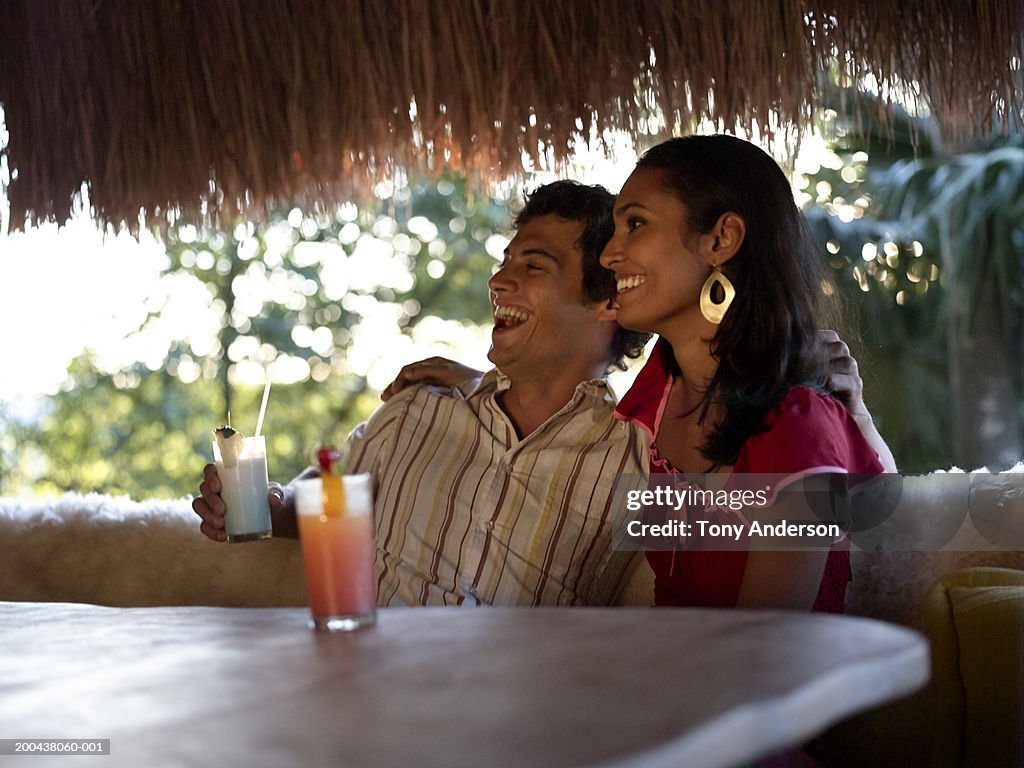 Couple at table with drinks laughing