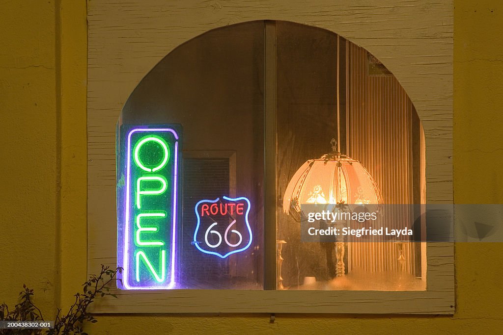 'Route 66' and 'open' neon signs in motel window