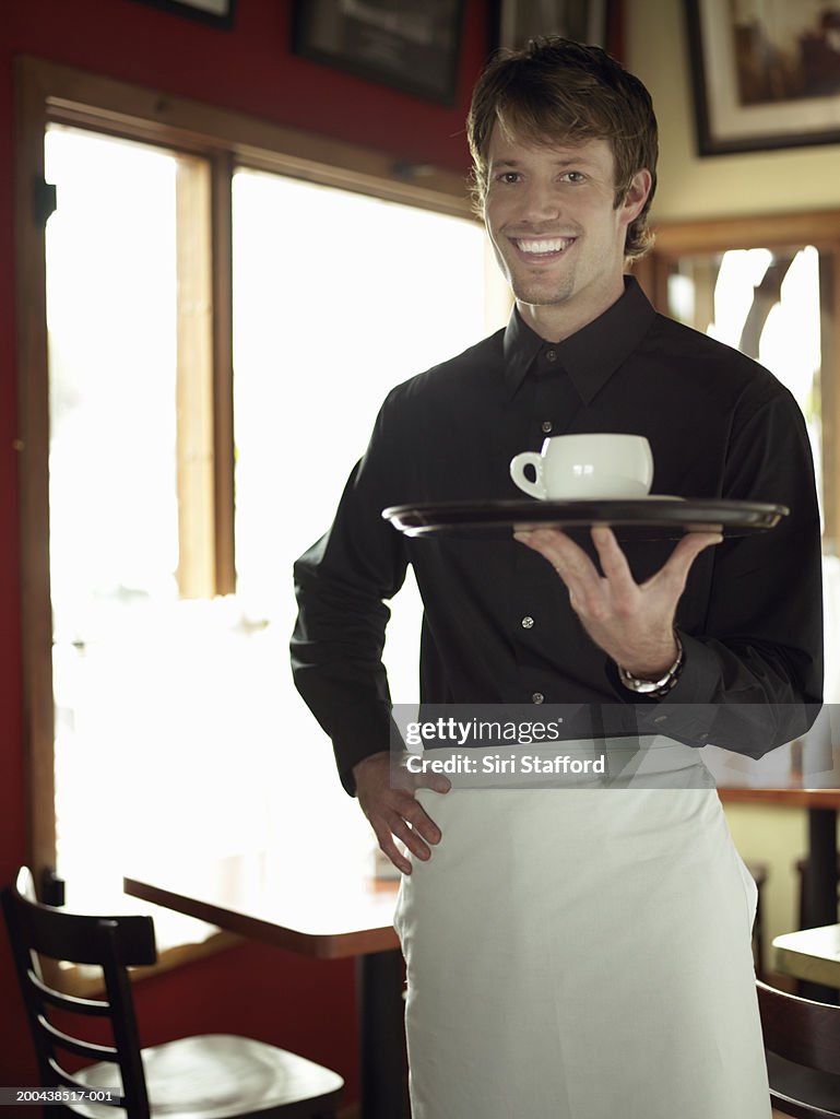 Waiter holding tray with coffee cup