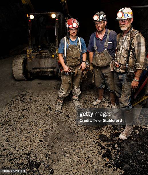 one female and two male coal miners near forklift in mine, portrait - coal miner foto e immagini stock