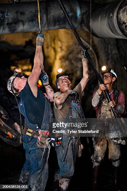 three coal miners installing ventilation tube in mine, clsoe-up - coal miner stock pictures, royalty-free photos & images