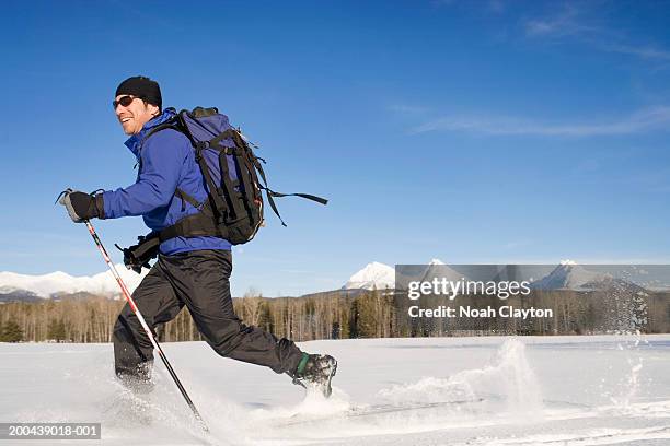 man cross country skiing, side view, winter - nordic skiing event fotografías e imágenes de stock