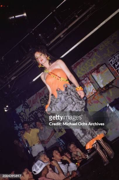 Fashion model, wearing an orange-and-grey outfit on the runway at the Graffiti Fashion Show, held at the Danceteria on West 21st Street in Manhattan,...