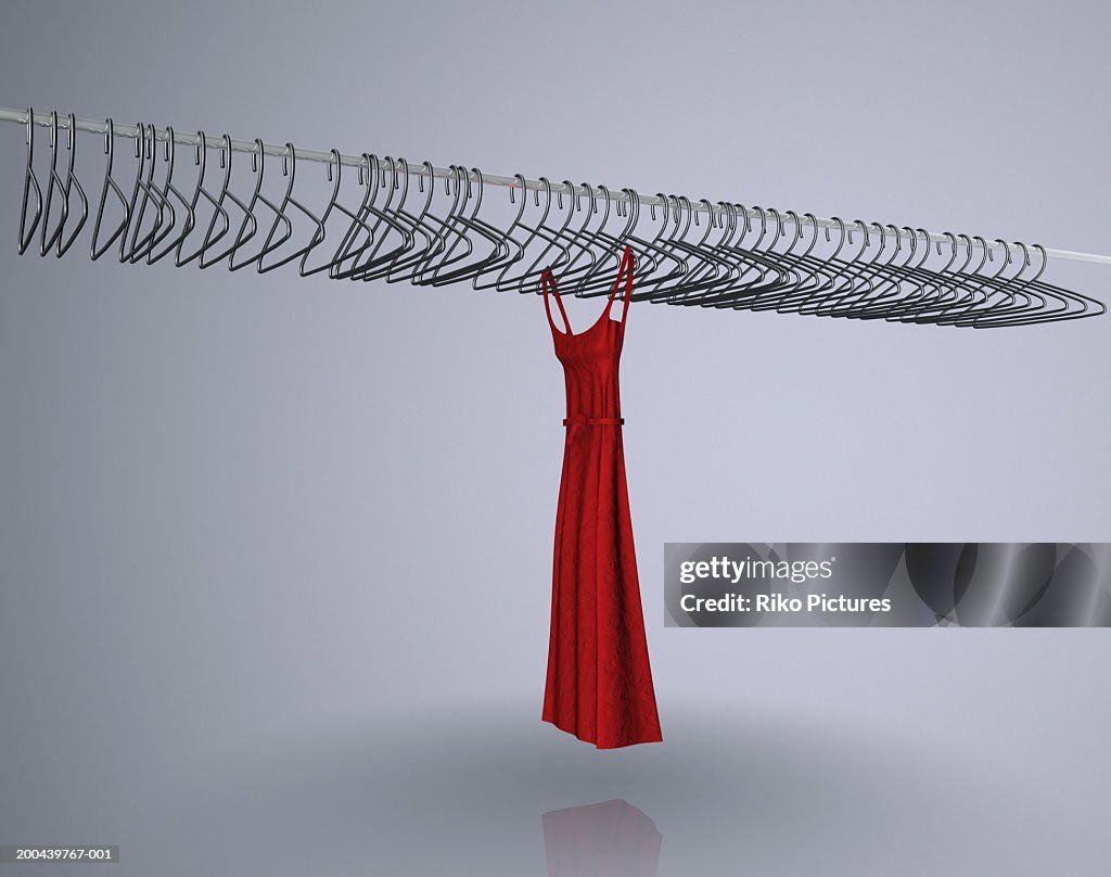 Red dress hanging on rail with empty coat hangers (Digital Composite)