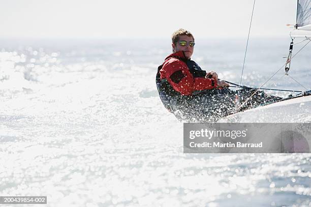 young man sailing boat on sea leaning over side, portrait - championships day one stock pictures, royalty-free photos & images