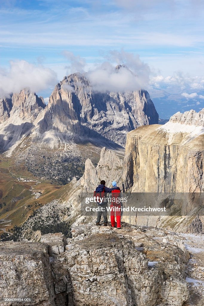 Italy, Alto Adige, young couple standing on mountain top, rear view