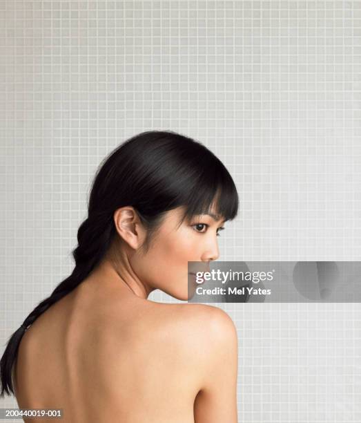 naked young woman looking over shoulder, rear view - regarder par dessus son épaule photos et images de collection