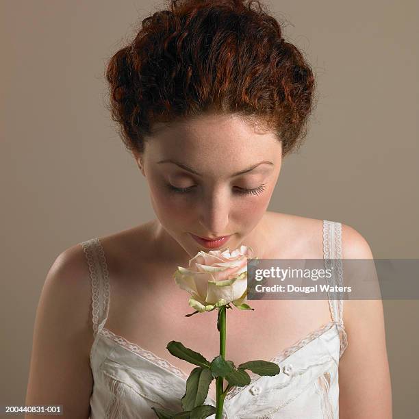 young woman smelling rose, close up - single rose stock pictures, royalty-free photos & images