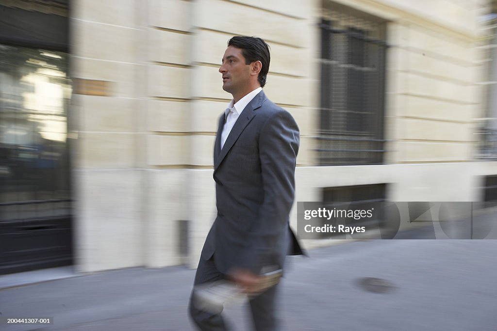 France, Paris, businessman in street (blurred motion)