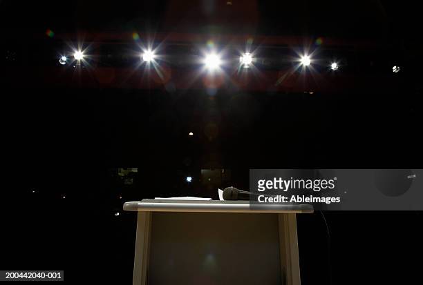microphone on lectern in illuminated auditorium - lectern stock pictures, royalty-free photos & images