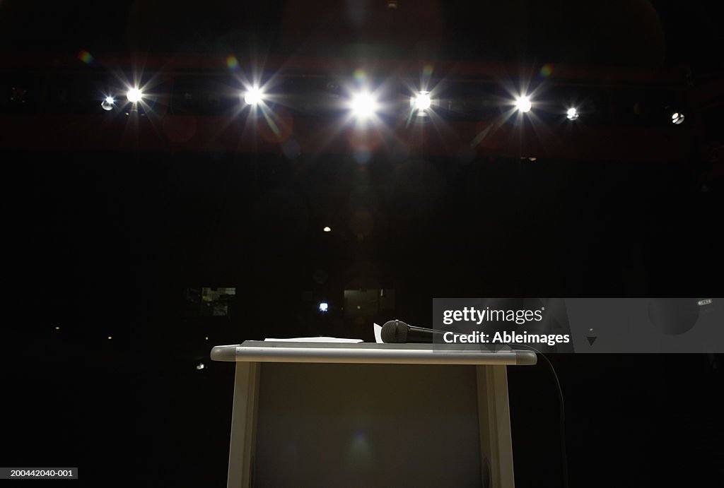 Microphone on lectern in illuminated auditorium