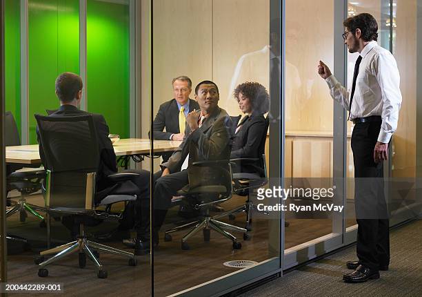 business executives in meeting, man interrupting  with knock on glass - exclusion stock-fotos und bilder