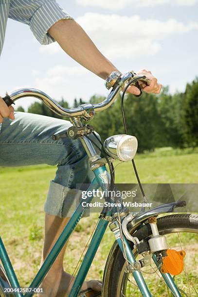 young man on bicycle, close-up of handlebars - fahrradlampe stock-fotos und bilder