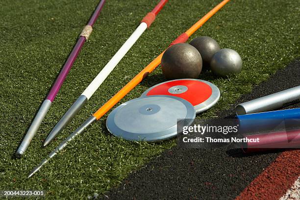 javelins, discuses, relay batons and shots beside track - jabalina fotografías e imágenes de stock