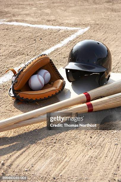 baseball glove, balls, bats and baseball helmet at home plate - baseball helmet stockfoto's en -beelden