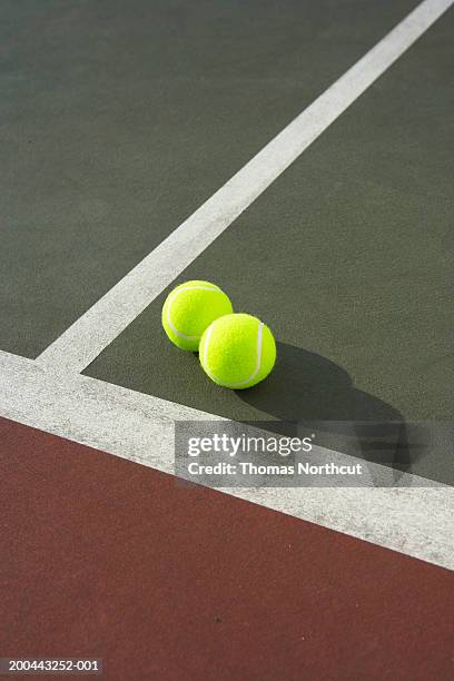 two tennis balls on tennis court, elevated view - tennis ball stock pictures, royalty-free photos & images