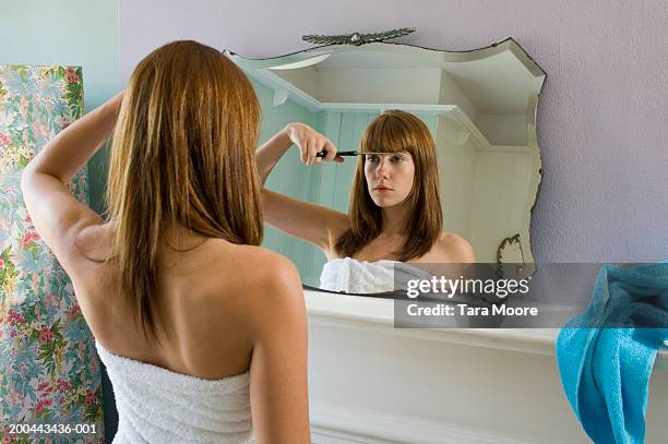 young woman wearing towel cutting fringe in mirror, rear view - woman rear view mirror stock pictures, royalty-free photos & images