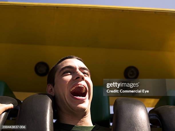 young man enjoying amusement park ride, close-up - parque de diversiones fotografías e imágenes de stock