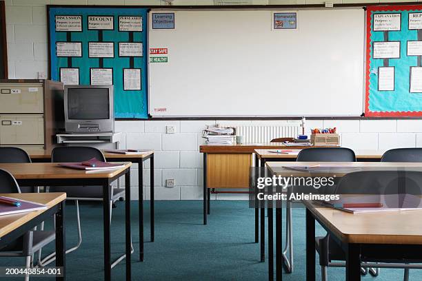 empty school classroom, exercise books and pens on table - assenza foto e immagini stock