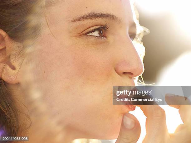 teenage girl (18-20)  licking finger, close-up - enjoying food stock-fotos und bilder