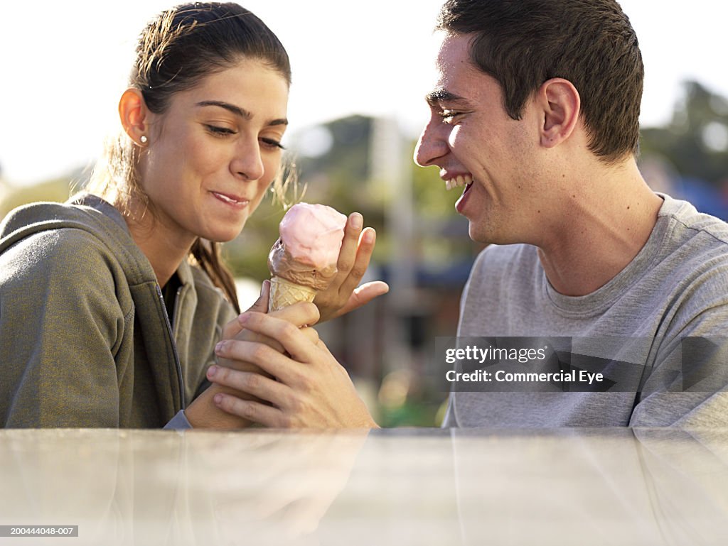 Young couple with ice cream, side view