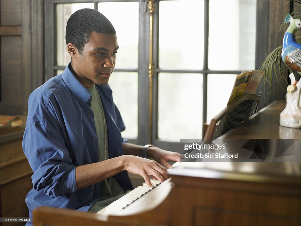 Young man playing piano in house
