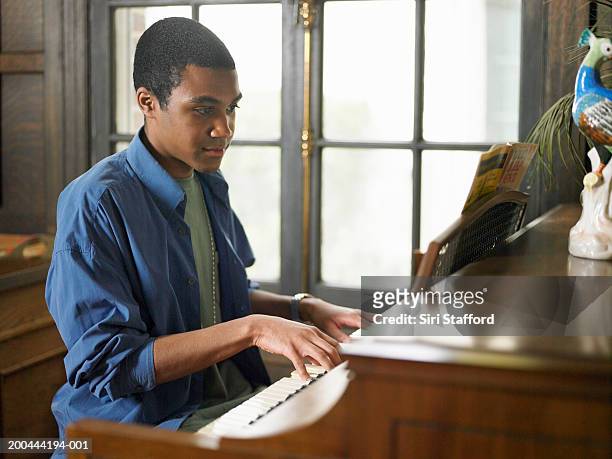 young man playing piano in house - pianist stock pictures, royalty-free photos & images