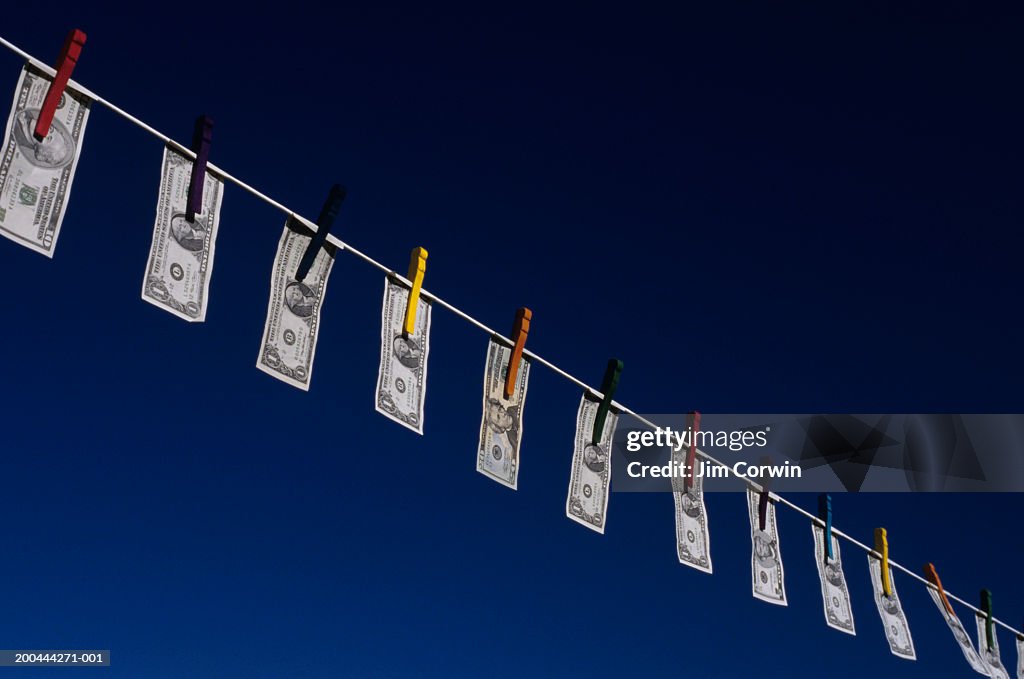 Money hanging from washing line, low angle view