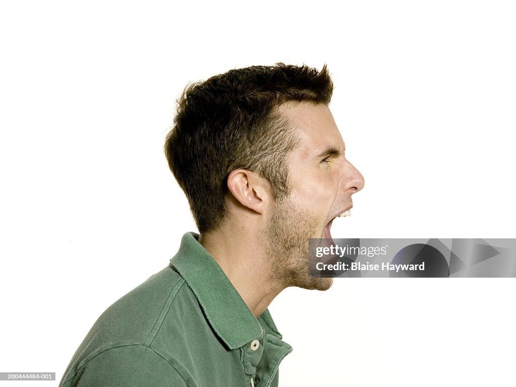 Young man yelling, side view